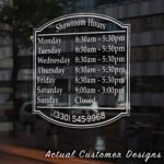 Storefront open hours decal with business name, phone number, and website