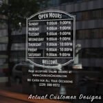 Storefront open hours decal with business name, phone number, and website